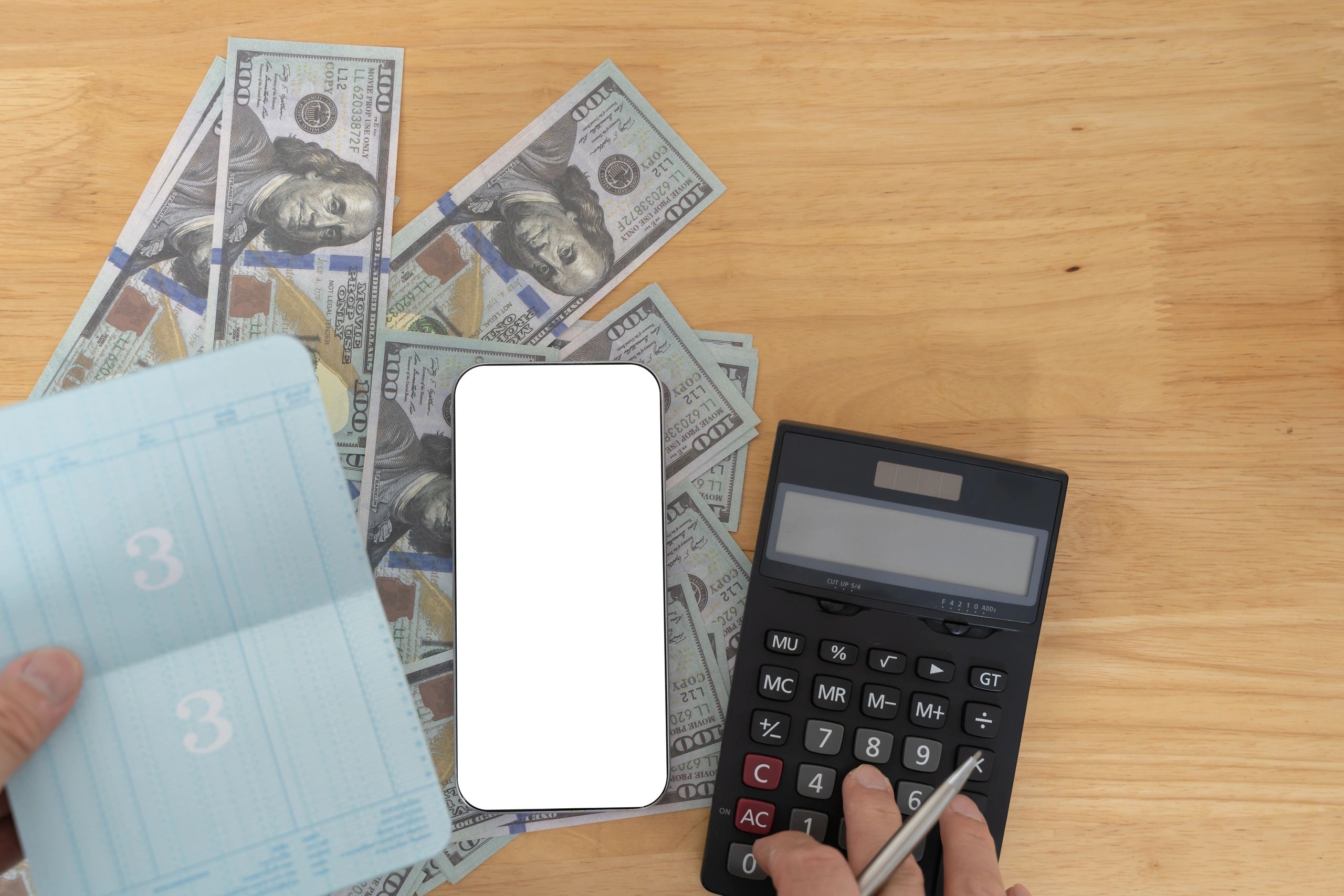 Budgeting tools and smartphone on a desk representing bookkeeping review